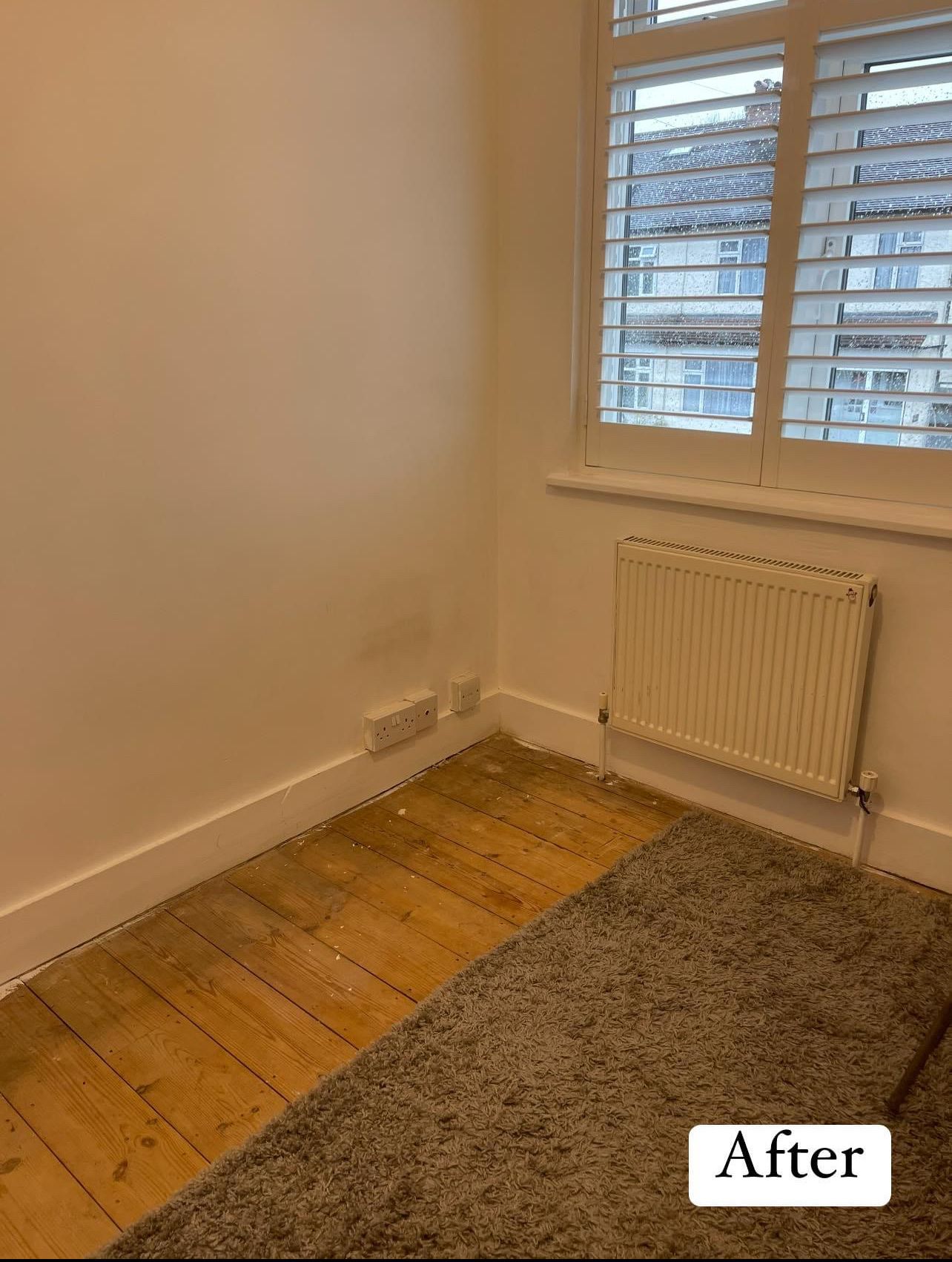 After: the same room emptied and cleaned, with bare walls, a wooden floor and a grey rug